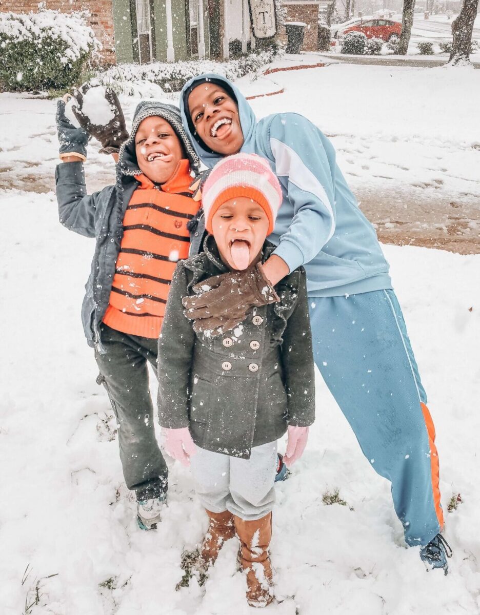 three children playing in the snow