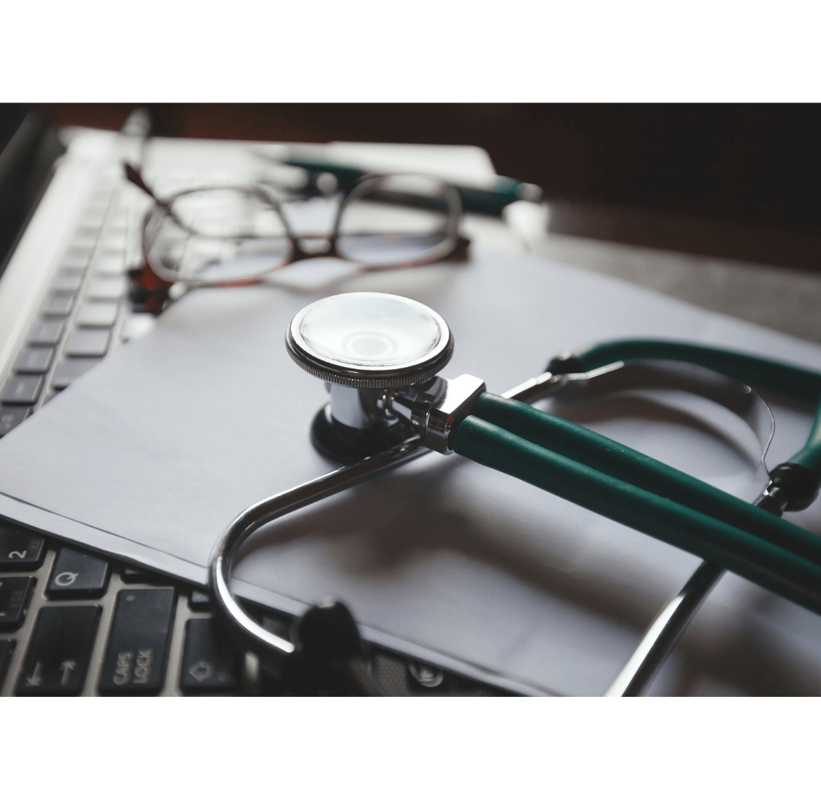 stethoscope and medical tools on laptop used during recovery planning