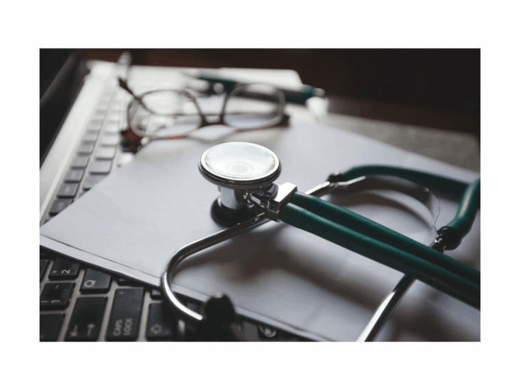 stethoscope and medical tools on laptop used during recovery planning